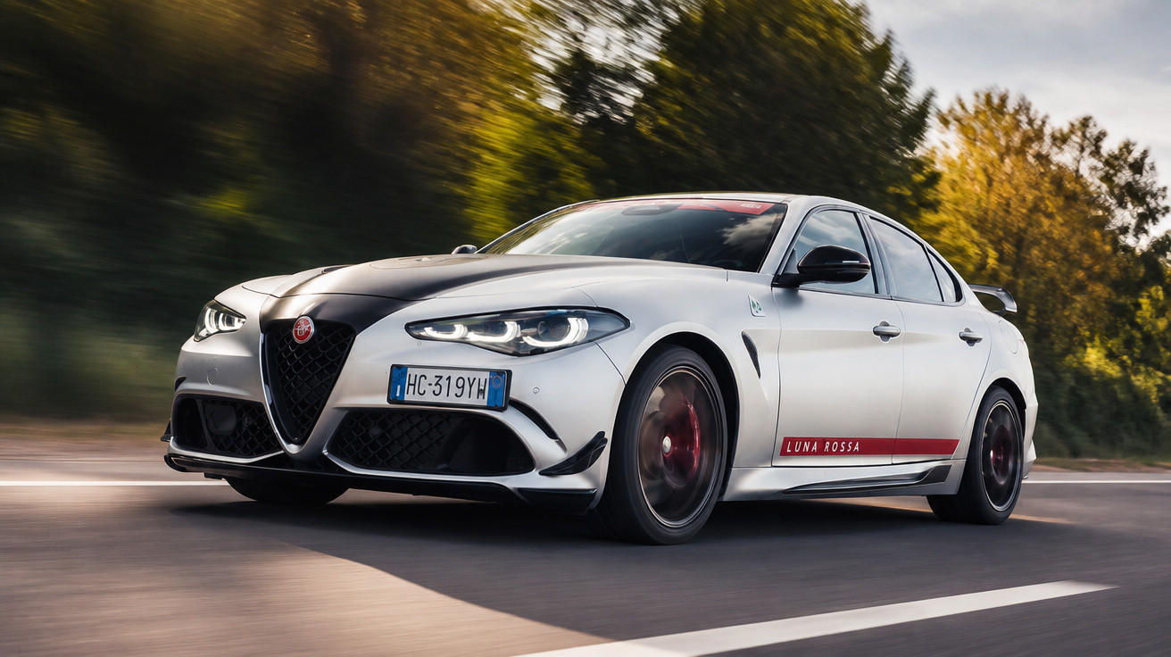 Carro de alto desempenho Alfa Romeo branco com faixa preta e detalhes vermelhos em estrada com árvores ao fundo.
